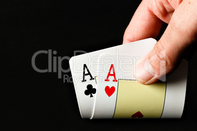 Hand holding two aces.
