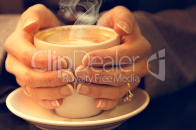 Woman holding coffee latte.