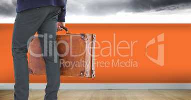 Businessman with briefcase and orange wall
