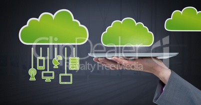 Hand holding tablet with cloud icons and hanging connection devices