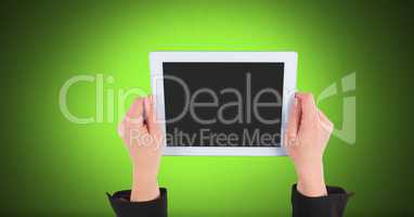 Hand holding tablet with green background