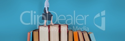 Business woman climbing books with blue background