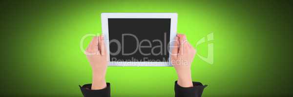 Hand holding tablet with green background