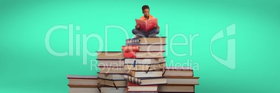 Boy reading and sitting on a pile of books and green background