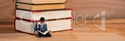Boy reading on the floor next to a pile of books