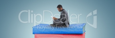 Business man reading on a pile off books and grey background