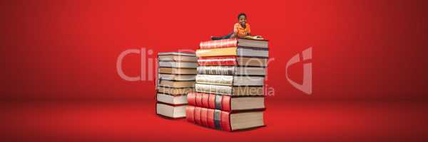 Boy reading on a pile of books with red background