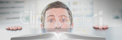 Man looking at an opened book with lights on a table