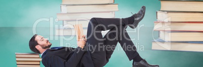 Businessman reading surrounded by piles of books and green background