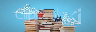 Piles of books with climbing silhouette and clouds on blue background