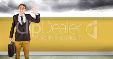 Businessman waving with yellow wall