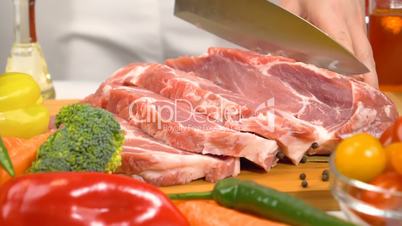 Slicing fresh raw meat for cooking in slow motion