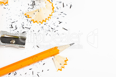 Pencil, metal sharpener and pencil shavings.