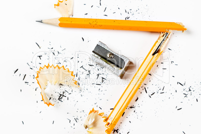 Broken pencil with metal sharpener and shavings.