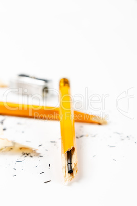 Broken pencil with metal sharpener and shavings.