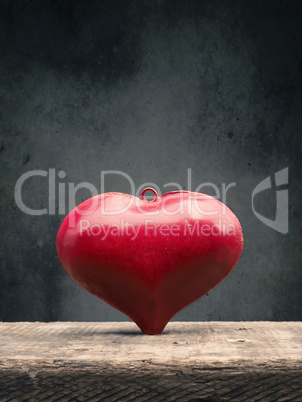 Red metal heart on a wooden table