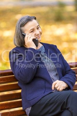 Senior woman talking on smartphone outdoors