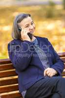 Senior woman talking on smartphone outdoors