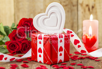 Shape of white heart in front of bouquet of red roses