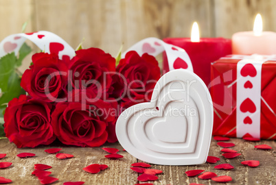Shape of white heart in front of bouquet of red roses