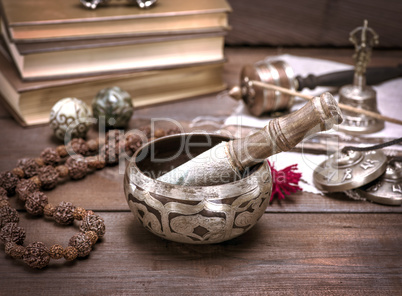 a copper singing bowl and a wooden stick