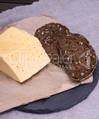piece of cheese and slices of rye bread with seeds