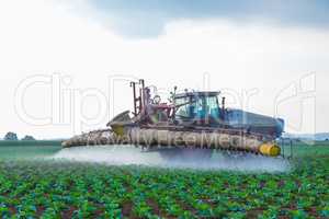 tractor sprays weed killer glyphosat on field