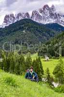 Woman in front of the church Ranui in South Tyrol