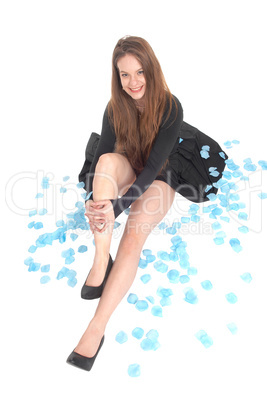 Beautiful woman sitting on floor with rose petals