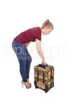Woman bending down for her suitcase