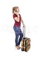 Woman standing with suitcase talking on phone