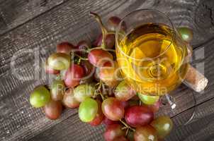 Glass of white wine with a cluster of grapes