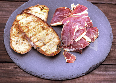 toast of white bread and pieces of jamon