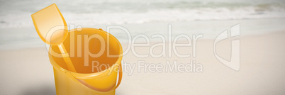 Composite image of yellow bucket and shovel