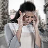 Composite image of businesswoman having an headache