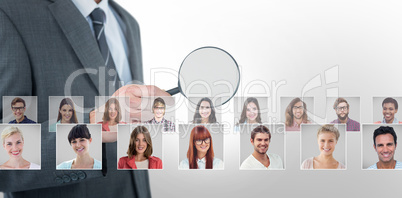 Composite image of mid section of businessman holding magnifying glass