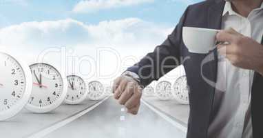 Businessman looking at watch with time clocks on surreal road