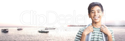 Travelling boy with bag in front of sea boats landscape