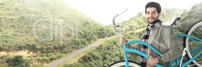 Travelling man with bicycle in front of landscape terrain