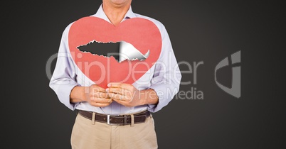 Man holding hurt love heart with torn paper