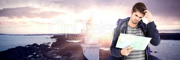 Travelling man with bag and map in front of sea lighthouse landscape