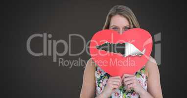 Woman holding hurt love heart with torn paper