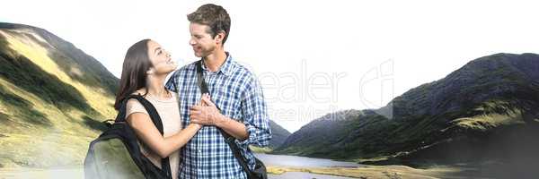 Travelling couple with bags in front of landscape