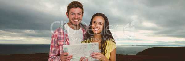 Travelling couple with map in front of landscape