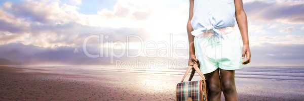 Travelling girl with bag in front of sea landscape