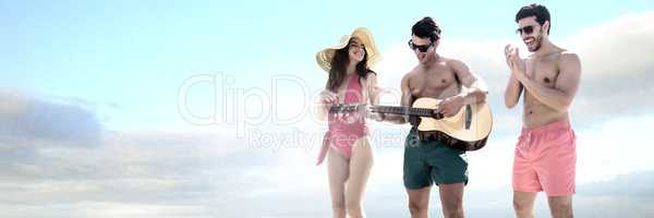 Friends playing guitar and having fun in swim wear holiday