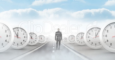 Businessman walking on road with surreal time clocks perspective