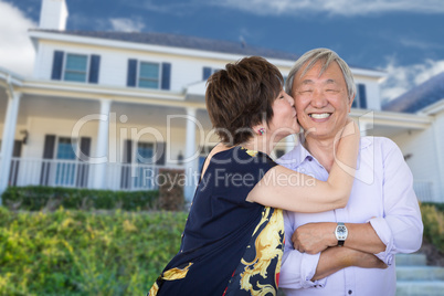 Happy Chinese Senior Adult Couple Kissing In Front Of Custom Hou