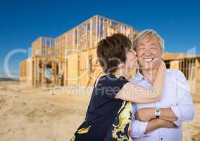 Chinese Senior Adult Couple Kissing In Front Of New House Framin