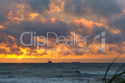 sunset on the sea, the waves beat against the breakwater, the sea at dawn, the ships on the horizon